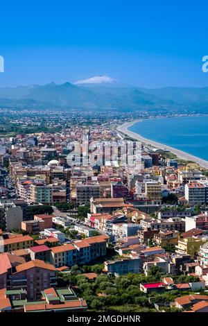 Veduta aerea della città di Milazzo, situata sul mare, e del vulcano Etna, Mongibello, in lontananza. Foto Stock