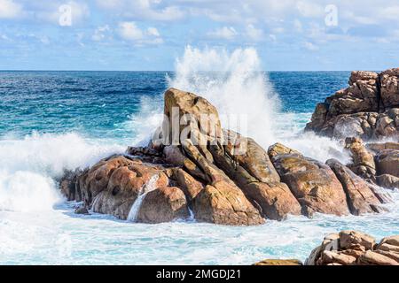 Onde che si infrangono su rocce metamorfiche di granito gneiss lungo la costa di Yallingup nell'Australia Occidentale Foto Stock