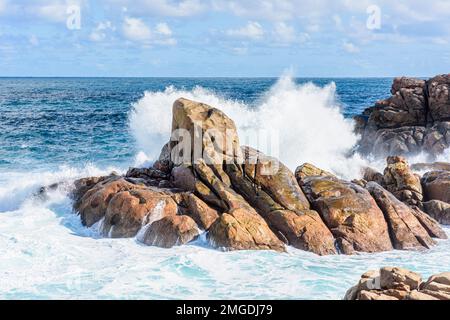 Onde che si infrangono su rocce metamorfiche di granito gneiss lungo la costa di Yallingup nell'Australia Occidentale Foto Stock