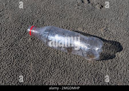 Bottiglia vuota di plastica scaricata su una spiaggia Foto Stock