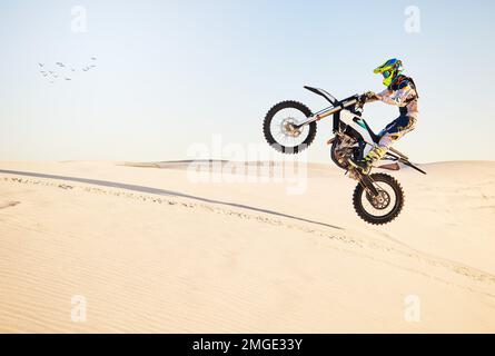 Moto, corsa nel deserto e salto aereo per gli esperti di sport estremi con velocità, potenza o equilibrio agili nella natura. Moto uomo, rally e cielo blu su veloce Foto Stock