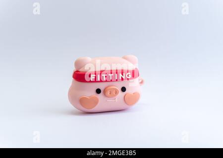 Figurina di maialino rosa con fascia da ginnastica su sfondo bianco isolato. Esercizio fisico, fitness, concetto di stile di vita sano Foto Stock