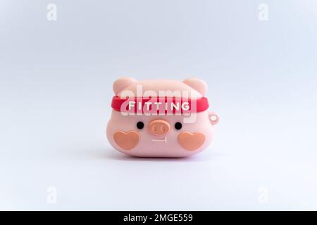 Figurina di maialino rosa con fascia da ginnastica su sfondo bianco isolato. Esercizio fisico, fitness, concetto di stile di vita sano Foto Stock