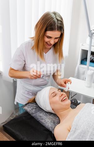 Donna che riceve iniezioni anti-invecchiamento. Iniezione cosmetica di botox Foto Stock