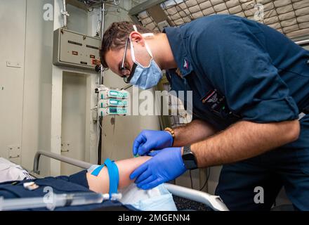 220824-N-JO823-1109 YOKOSUKA, Giappone (24 agosto 2022) Ospedale Corpsman 2nd Classe Aaron Aslam, da Russellville, Arkansas, conduce una formazione medica su come somministrare un IV a bordo degli Stati Uniti L’unica portaerei della Marina schierata a termine USS Ronald Reagan (CVN 76), agosto 24. Ronald Reagan, il fiore all'occhiello del Carrier Strike Group 5, fornisce una forza pronta per il combattimento che protegge e difende gli Stati Uniti, e sostiene alleanze, partnership e interessi marittimi collettivi nella regione del Pacifico. Foto Stock