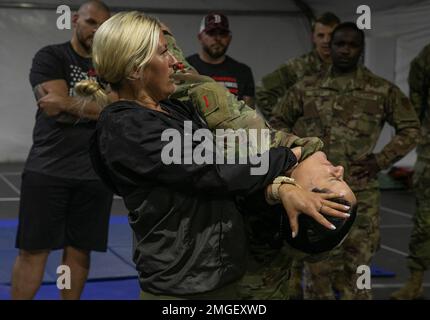 Il combattente misto di arti marziali Ashley Yoder dimostra una tecnica di difesa con gli Stati Uniti Esercito CPT. Kamilah Cruz Méndez, comandante di Signal, Intelligence, and Sostainment Company, a Bolesławiec, Polonia, 24 agosto 2022. I combattenti della MMA Ashley Yoder, Parker Porter, ed Herman e Sam Alvey visitano installazioni militari in tutta Europa come parte del loro tour "Cage Crusader" per aumentare il morale e consentire ai soldati di imparare vari fondamentali di combattimento. Foto Stock