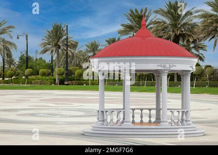 Urban Infrastructure Garden o Park Circle Gazebo con colonne greche e tetto verde, o Pergola su una strada vuota della città con palme estrema closeu Foto Stock