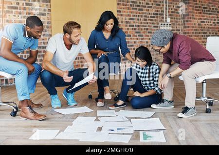 Lavorando alla loro nuova campagna pubblicitaria. un gruppo di uomini d'affari che si occupano di brainstorming in un ufficio. Foto Stock