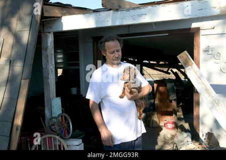 Aftermath - la gente ritorna a casa - 26-HK-43-52. Slidell Return--uomo che tiene il cane di fronte alla casa danneggiata--da Andrea Booher-FEMA. Uragano Katrina Foto Stock