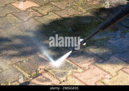 Pavimento esterno la pulizia con getto di acqua ad alta pressione Foto Stock