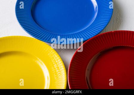 Diversi colori delle piastre vuote. Sfondo bianco. Piastra di argilla rossa, blu e gialla. Foto Stock