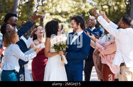 Confetti, coppia di nozze e celebrazione del matrimonio di folla che gettano petali di fiori all'aperto. Felicità, evento emozionato e sociale con la sposa e l'uomo Foto Stock