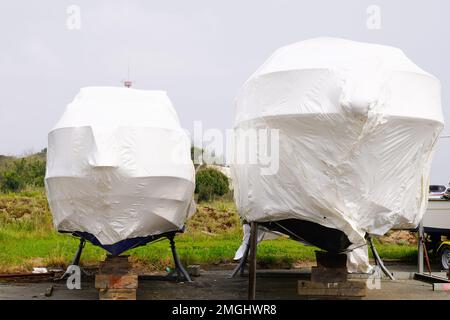 l'acqua di parcheggio del motoscafo protetta da una pellicola di plastica per l'inverno di svernamento sulla barca a vela immagazzinata per l'inverno freddo di stagione Foto Stock