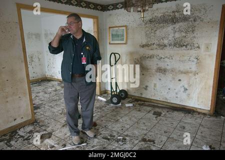 Aftermath - Vice Direttore Federale di coordinamento Ted Monette - 26-HK-32-10. DFCO Ted Monette parlando al telefono in una stanza residenziale danneggiata--Andrea Booher foto FEMA. Uragano Katrina Foto Stock