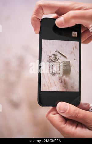 Telefono, arte e mani scatta foto creative o foto di un mestiere di argilla in un workshop per l'aggiornamento dei social media. Artista, persona orgogliosa e artistica Foto Stock