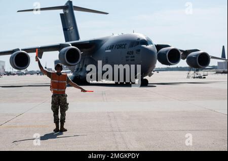 Un Airman assegnato al 305th Aircraft Maintenance Squadron marshalles un C-17 Globemaster presso la base comune McGuire-Dix-Lakehurst, New Jersey, 24 agosto 2022. Questo aeromobile della 305th Air Mobility Wing e la sua unità di riserva associata, la 514th Air Mobility Wing, con sede a JBMDL, ha praticato una missione di rifornimento con un ingresso di basso livello in una posizione ostile simulata, rispondendo al contempo a missili superficie-aria lanciati da un nemico a Fort Indiantown Gap, Pennsylvania. Foto Stock