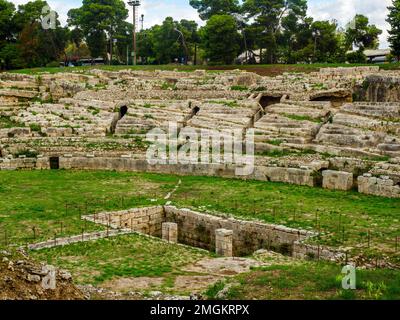 Anfiteatro Romano di Siracusa - i sec. AD - III sec. AD - Parco Archeologico della Neapolis - Siracusa, Sicilia, Italia l'anfiteatro ha due ingressi ed è servito da un complesso sistema di scale che scendono dal piano superiore situato all'esterno. L'arena era dotata, al centro, di una grande sala rettangolare, originariamente coperta, collegata tramite un passaggio sotterraneo con l'estremità meridionale del monumento, sull'asse del corridoio d'ingresso. Intorno all'arena la cavea si distingue per un alto podio, dietro il quale corre un corridoio coperto con cancelli di accesso all'arena per i gladiatori A. Foto Stock