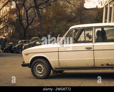 Vecchia auto bianca arrugginita sovietica lada in un cortile di un edificio residenziale a Yerevan Foto Stock