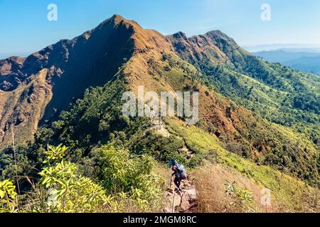 L'escursionista si dirige verso la cresta a coltello su Khao Chang Phueak, Parco Nazionale di Thong Pha Phum, Kanchanaburi, Thailandia Foto Stock