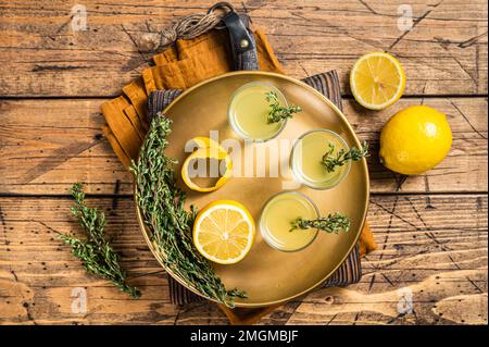 Shot di limoncello, liquore di limone italiano. Sfondo di legno. Vista dall'alto. Foto Stock