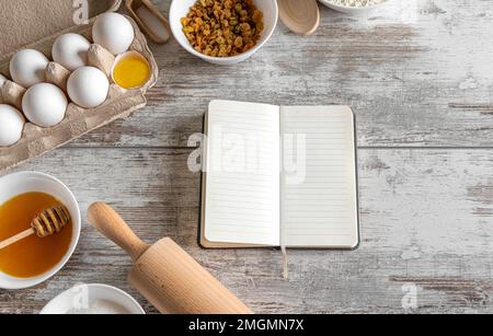 Blocco note e prodotti da forno sul tavolo. Foto Stock