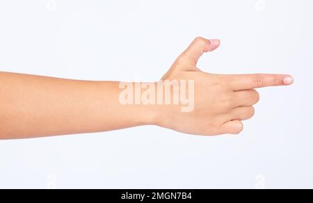 Mano, dito e puntamento con una donna in studio isolato su uno sfondo bianco facendo un gesto di pistola. Social media, icona ed emoji con una donna su Foto Stock