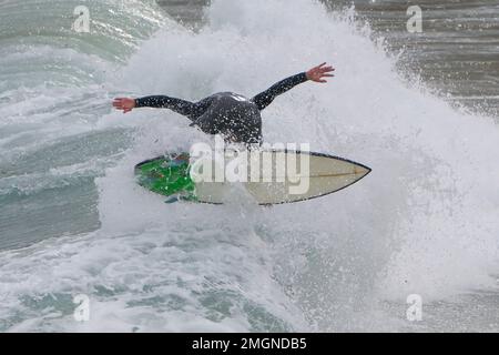 Surfista che cade fuori bordo come le onde crash in un wipeout Foto Stock