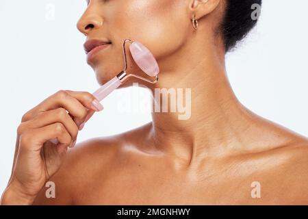 Cura della pelle, bellezza e donna con rullo di giada per il suo viso isolato su uno sfondo bianco in studio. Massaggio, benessere e cosmetici modello viso Foto Stock