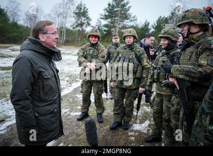 26 gennaio 2023, Sassonia-Anhalt, Möckern: Boris Pistorius (SPD), ministro federale della Difesa, si trova con i soldati durante la sua visita inaugurale alle forze armate tedesche nella zona di addestramento di Altengrabow. Seguendo le intuizioni sull'addestramento al fuoco e al combattimento dei logistici della base delle forze armate e dei fanti armati dell'esercito, il ministro ha tenuto colloqui con i soldati. Foto: Kay Nietfeld/dpa Pool/dpa Foto Stock