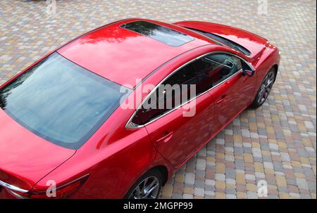 Auto rossa parcheggiata su Una lastra di pavimentazione colorata Vista dall'alto Foto Stock