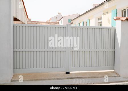 portale in acciaio grande bianco beige recinzione cancello in metallo sulla porta moderna chiara casa strada Foto Stock