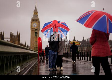 Una coppia si copre contro il tempo umido e ventoso sul Westminster Bridge nel centro di Londra. Data immagine: Giovedì 26 gennaio 2023. Foto Stock
