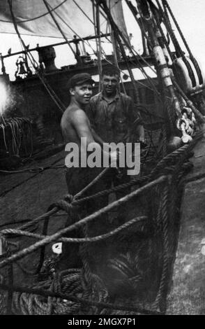 Due marinai in piedi sul ponte del barque d'acciaio a quattro alberi Hougomont, circa 1928. Foto Stock