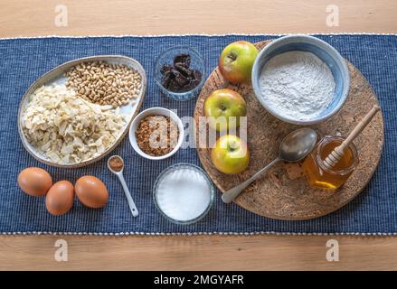 Ingredienti per cuocere una torta di mele e miele su un tavolo da cucina Foto Stock