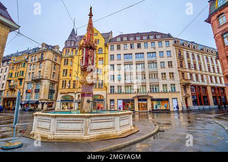 BASILEA, SVIZZERA - 1 APRILE 2022: Scenografica fontana Fischmarktbrunnen in piazza Alter Fischmarkt, il 1 aprile a Basilea, Svizzera Foto Stock