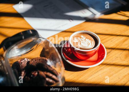 Tazza di latte con caffè caldo e latte art al bar del banco del caffè Foto Stock