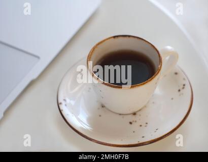 Una tazza con fragrante caffè nero sta sul tavolo Foto Stock