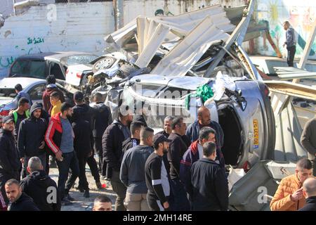 Jenin, Medio Oriente. 26th Jan, 2023. I palestinesi ispezionano i resti di strutture e veicoli distrutti, danneggiati da un bulldozer militare israeliano durante lo storming della città di Jenin nella Cisgiordania occupata. Le grandi forze dell'esercito israeliano hanno colpito la città di Jenin e hanno ucciso dieci palestinesi, tra cui una donna, e ferito più di venti altri con proiettili vivi durante gli scontri tra loro e le forze che li hanno confrontati. L'esercito ha detto che l'incursione era su un appartamento della cella nel campo profughi di Jenin, che ha avuto inizio dopo 'accurate informazioni di intelligence' fornite da t Foto Stock