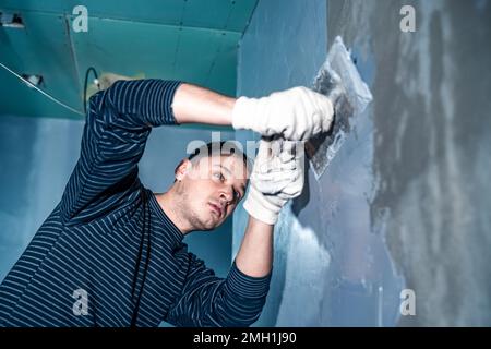 applicazione manuale di impermeabilizzazione alla parete in cantiere Foto Stock