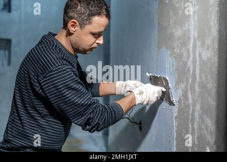 applicazione manuale di impermeabilizzazione alla parete in cantiere Foto Stock