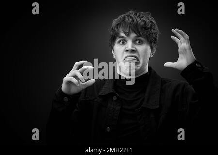 pazzo giovane uomo con capelli impressionante grimacing Foto Stock