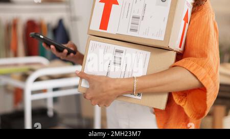 Scatola, ecommerce e donna nera piccola impresa proprietario ordini di imballaggio per la spedizione e la consegna nel suo ufficio, felice e allegro. Startup, retail e. Foto Stock