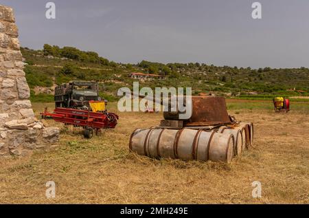 VIS, CROAZIA, EUROPA - attrezzature militari e agricole, all'interno dell'isola di Vis. Vecchia torretta cisterna su barili. Foto Stock