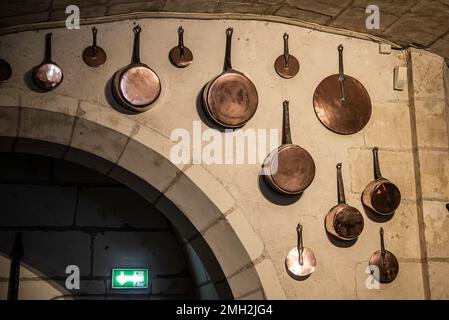 Chenonceau, Francia - 29 2022 dicembre: Gli utensili da cucina vintage appesi al muro nella cucina Chenonceau Castello Foto Stock