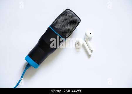 microfono nero e cuffie wireless bianche su sfondo isolato, microfono per musica, musica Foto Stock