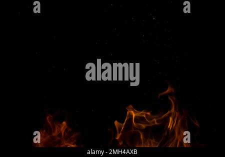 Scintille da una fiamma in movimento su sfondo nero. Astrazione di fiamma sfocata. Foto Stock
