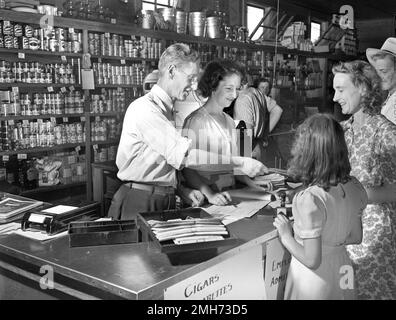 Cliente che riceve il cambiamento dal Clerk dopo aver fatto acquisti presso il Coopertic Store, Escambia Farms, Florida, USA, John Collier, Jr., Stati Uniti Ufficio delle informazioni di guerra, giugno 1942 Foto Stock