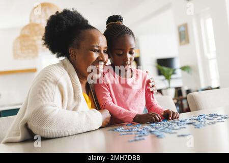 Felice afroamericana nonna e nipote fare puzzle Foto Stock