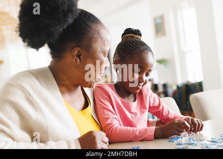 Felice afroamericana nonna e nipote fare puzzle Foto Stock