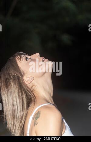 Giovane donna bionda cercando nella foresta Foto Stock